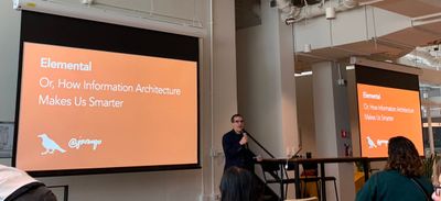 Jorge stands in front of his orange title slide Elemental: Or, How Information Architecture Makes Us Smarter.