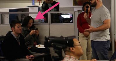 Me sitting in a crowd of attendees, eyes glued to my phone with my fingers flying.